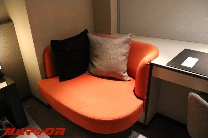 2人で寛げるオレンジのソファーが設置されています。